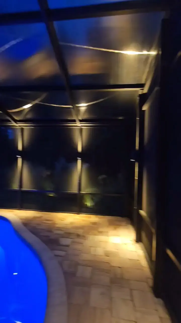 The spa and pool under warm sconces, the water lit blue